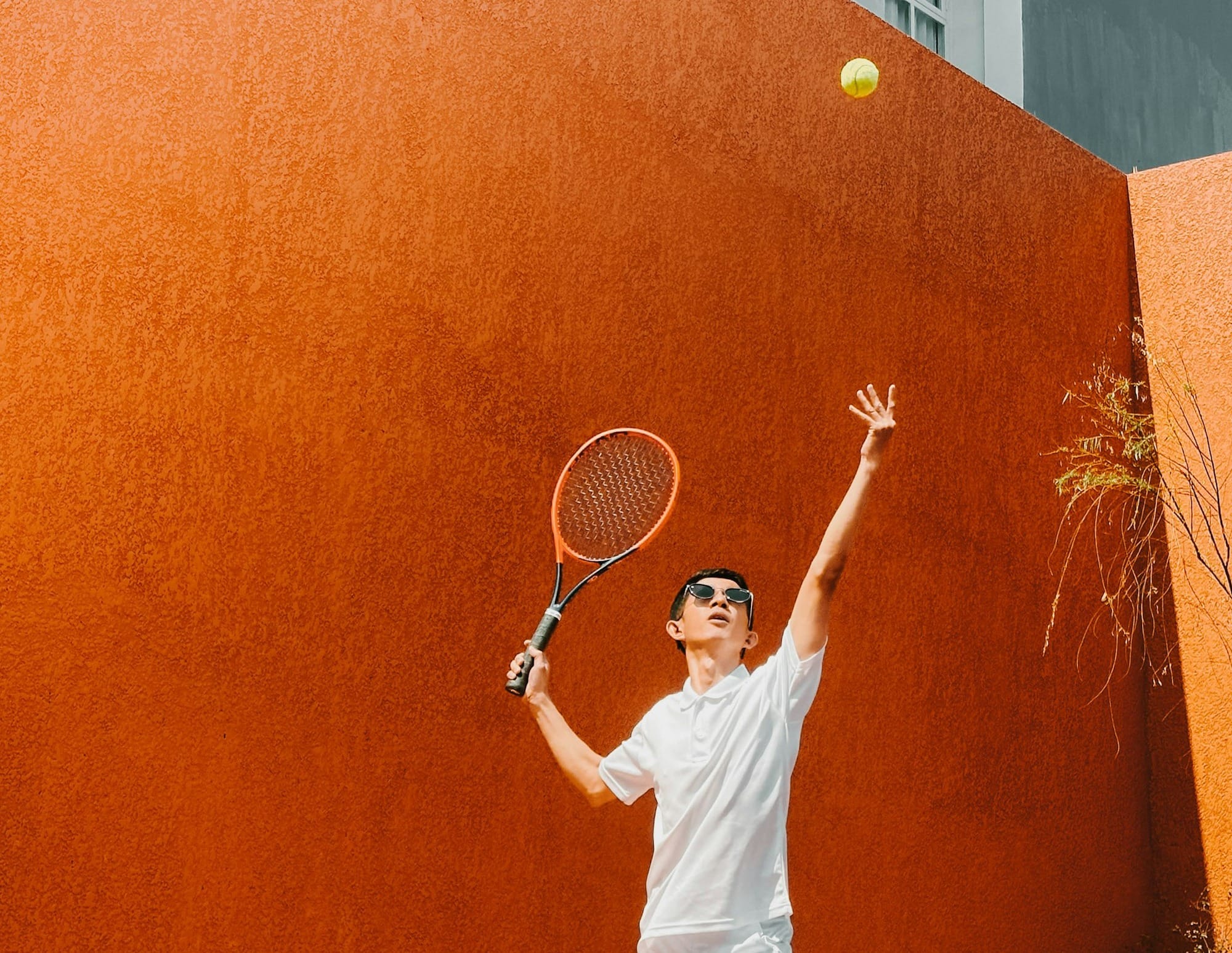 A man holding a tennis racquet on top of a tennis court