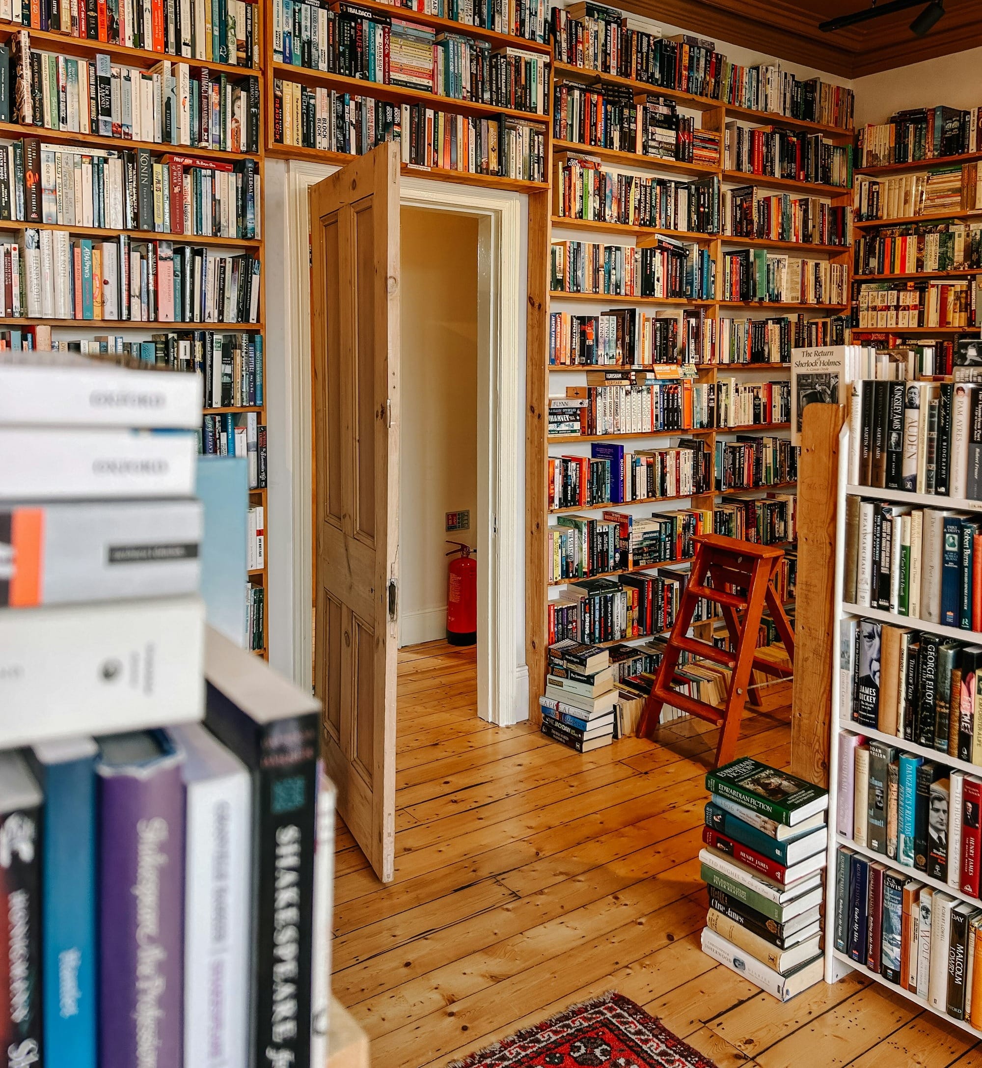 A bookshelf filled with lots of books next to a doorway